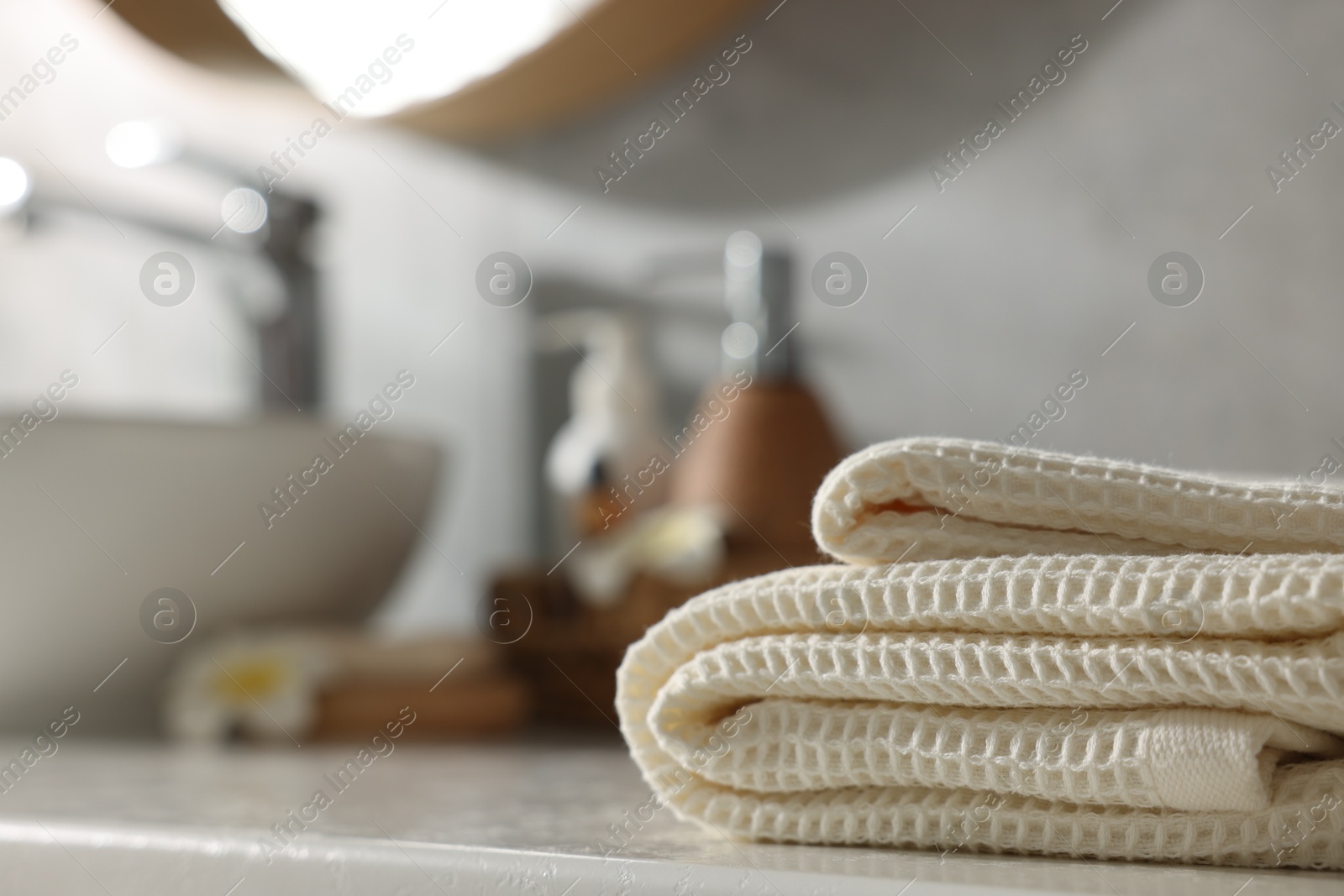 Photo of Fresh clean waffle towel on counter in bathroom, closeup