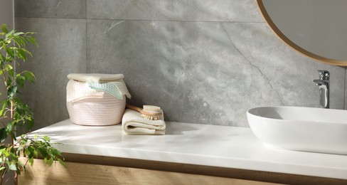 Photo of Clean waffle towels and brush near sink in bathroom