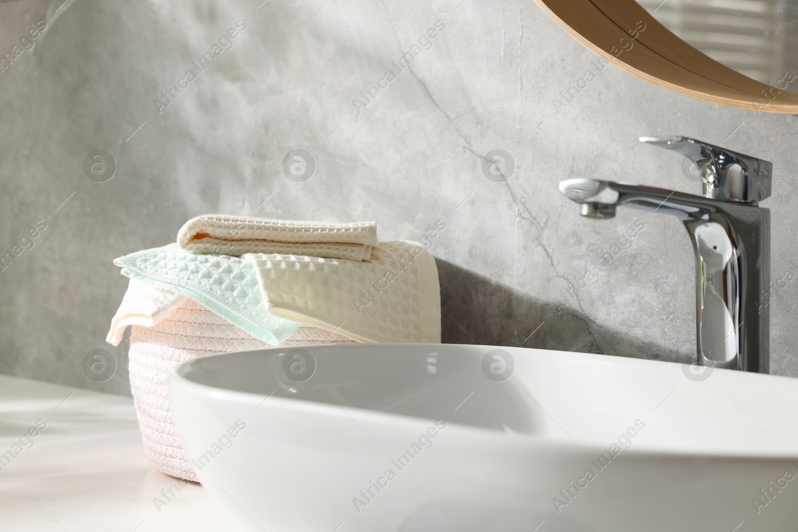 Photo of Clean waffle towels near sink in bathroom, closeup