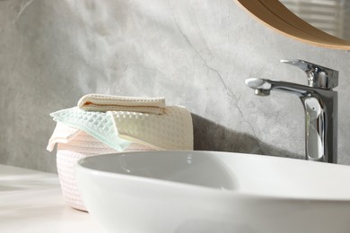 Photo of Clean waffle towels near sink in bathroom, closeup