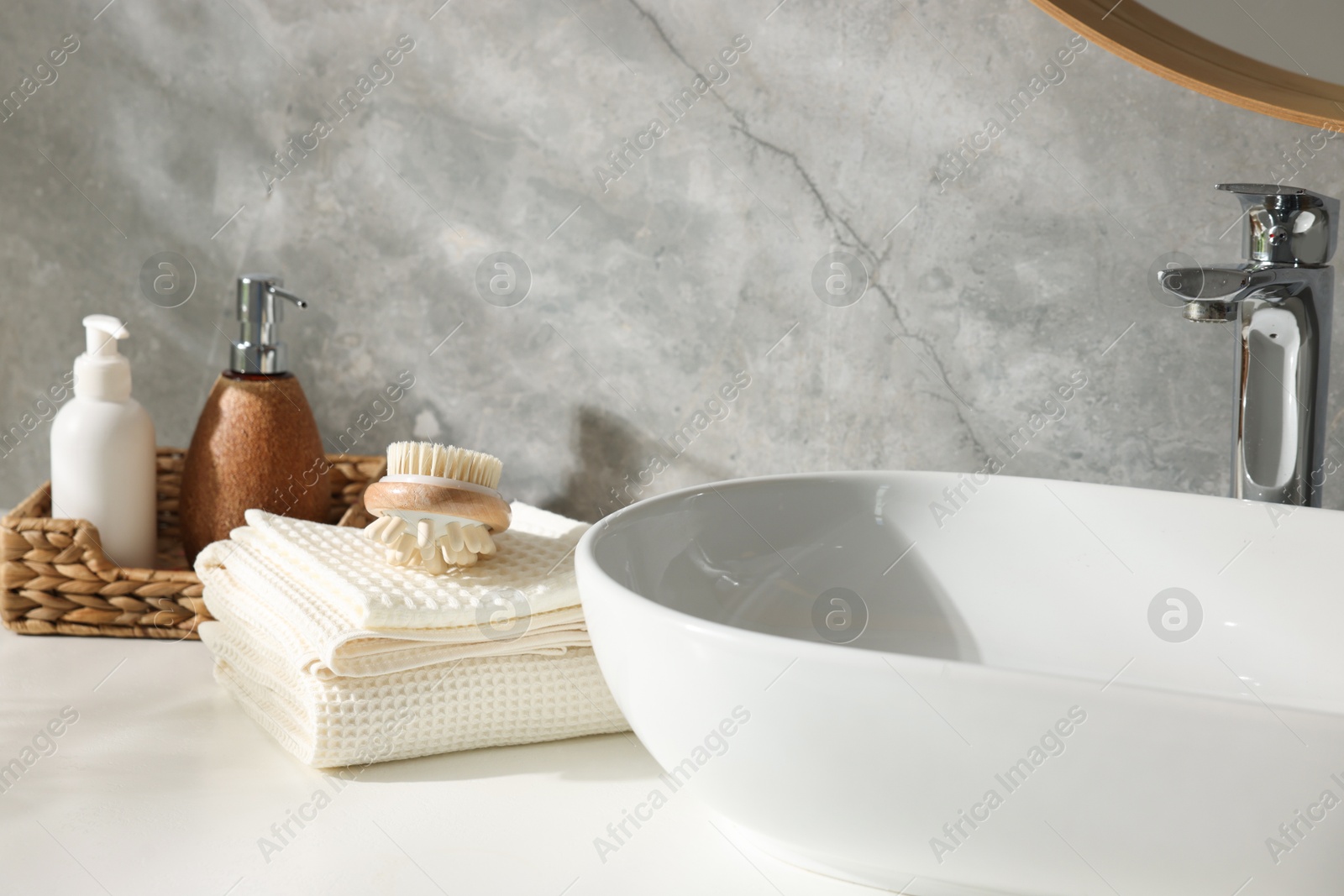 Photo of Clean waffle towels, brush and cosmetic products on counter in bathroom