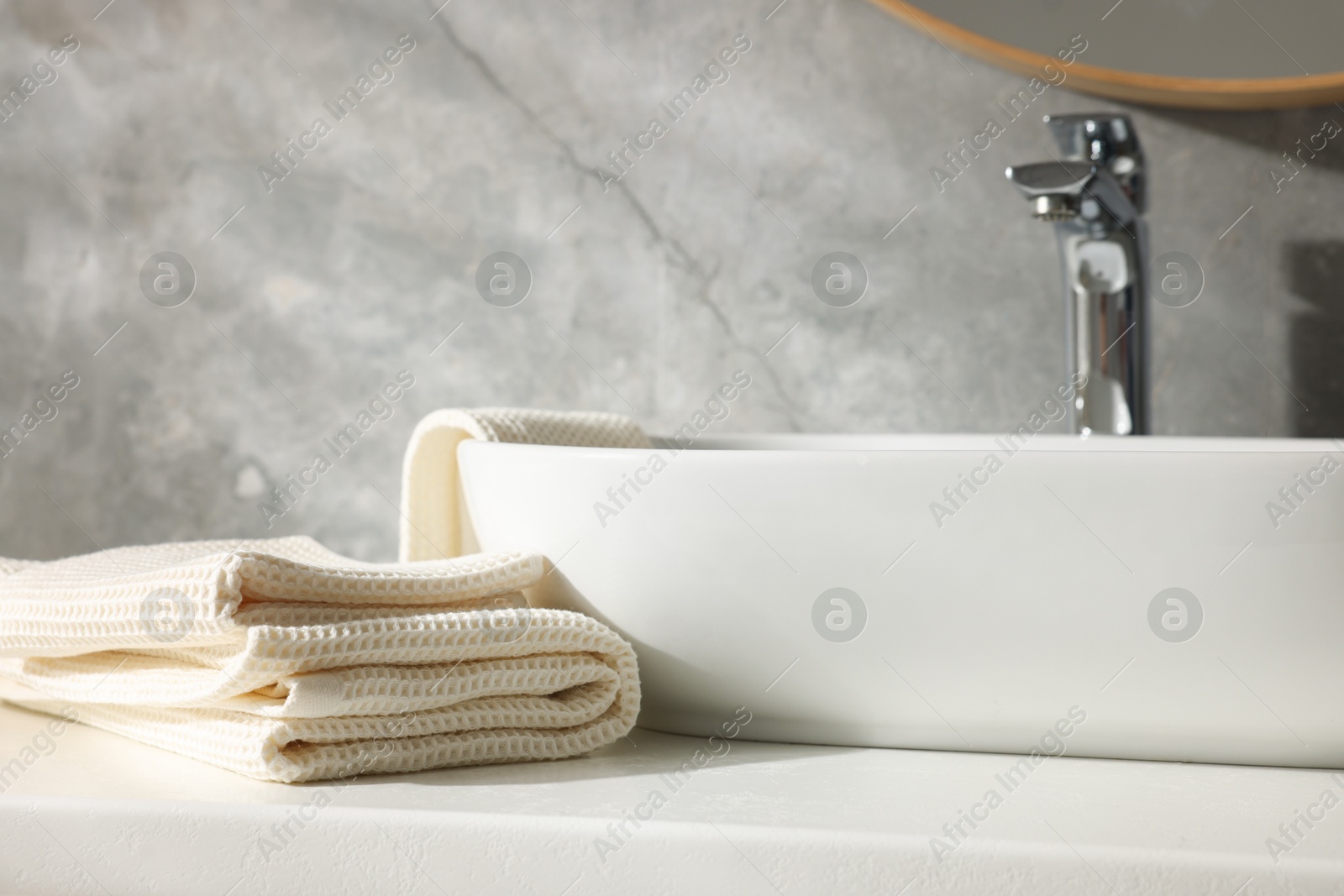 Photo of Clean waffle towels near sink in bathroom, closeup
