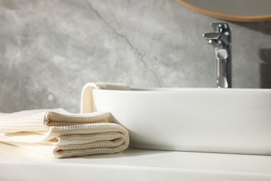 Photo of Clean waffle towels near sink in bathroom, closeup