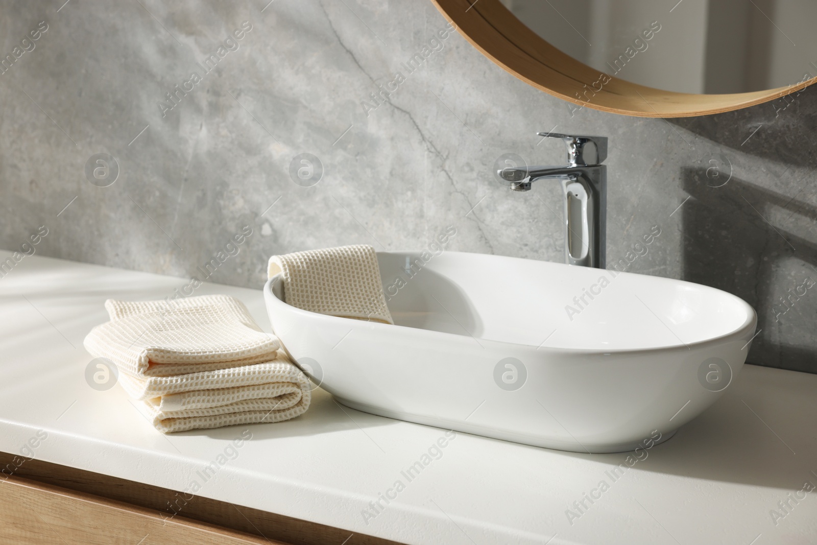 Photo of Clean waffle towels near sink in bathroom