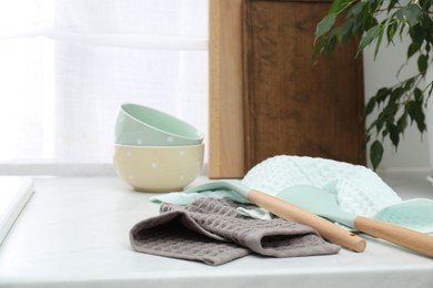 Photo of Clean bowls and utensils drying on waffle towels in kitchen