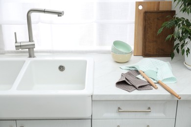 Photo of Clean bowls and utensils drying on waffle towels in kitchen