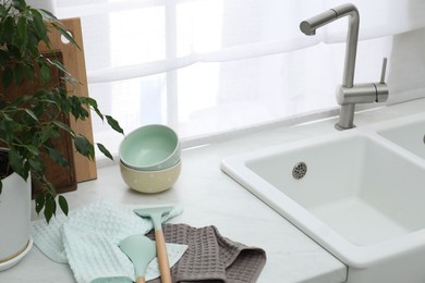 Photo of Clean bowls and utensils drying on waffle towels in kitchen