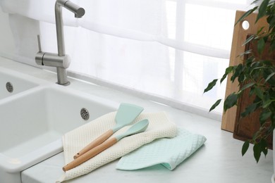 Photo of Clean utensils drying on waffle towels in kitchen