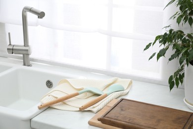 Photo of Clean cutting boards and utensils drying on waffle towel in kitchen