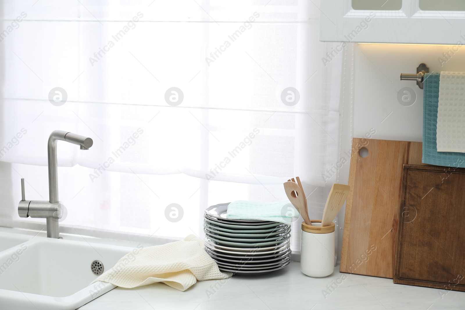 Photo of Clean dishware and waffle towel on countertop in kitchen