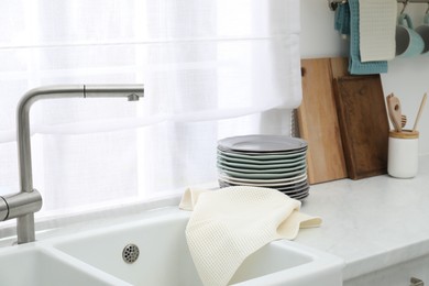 Photo of Clean dishware and waffle towel on countertop in kitchen