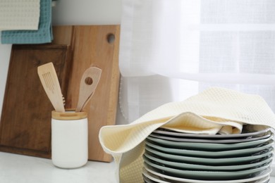 Photo of Clean dishware and waffle towel on countertop in kitchen, closeup