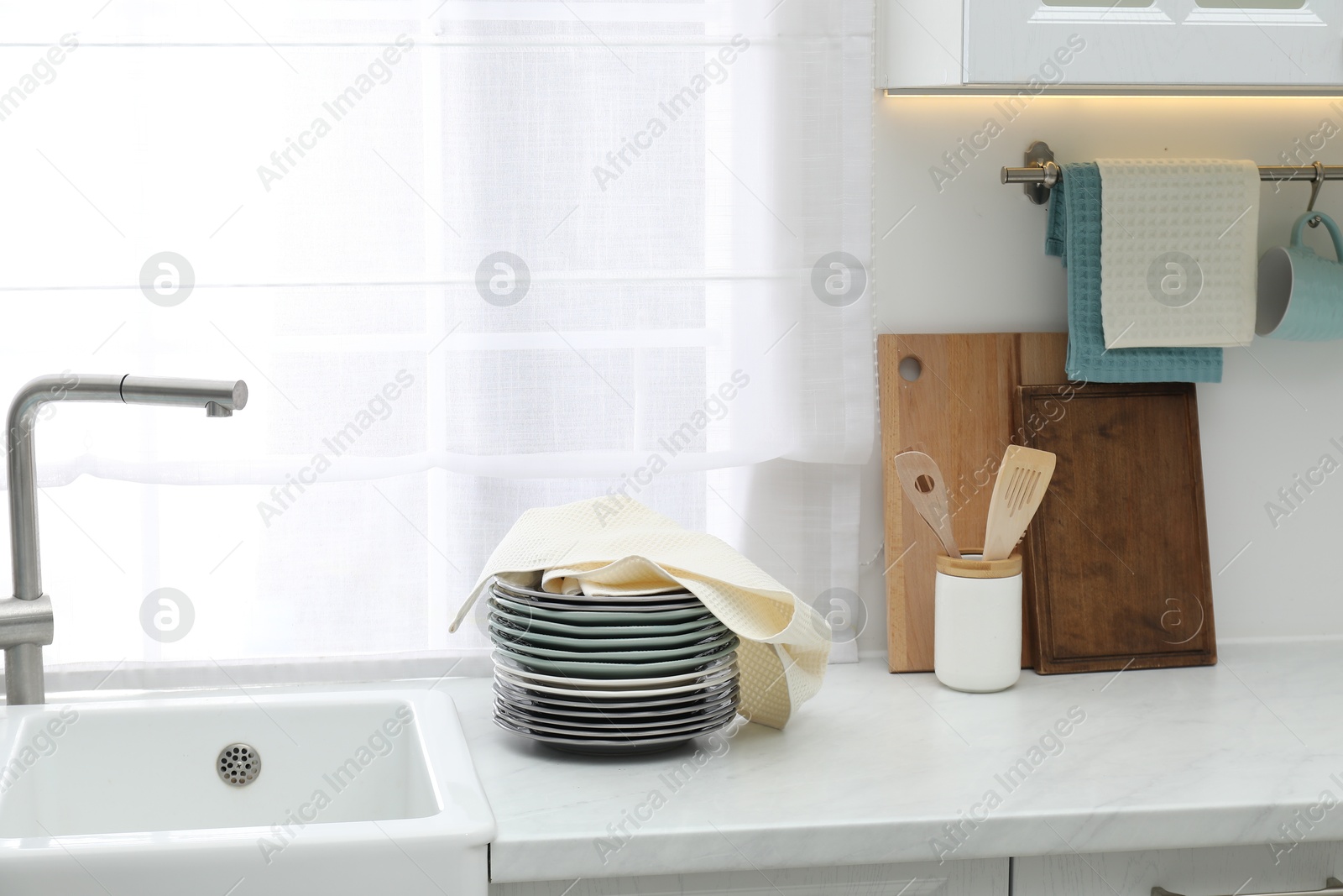 Photo of Clean dishware and waffle towel on countertop in kitchen