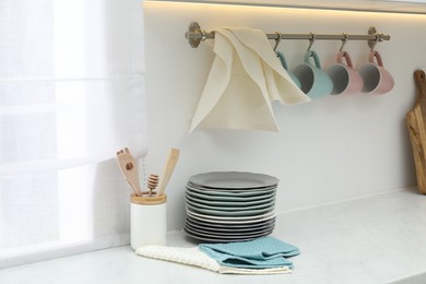 Photo of Clean dishware and waffle towels on countertop in kitchen