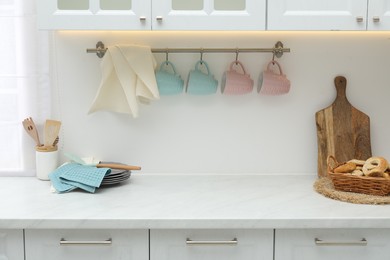 Photo of Clean dishware, waffle towels and pretzels on countertop in kitchen