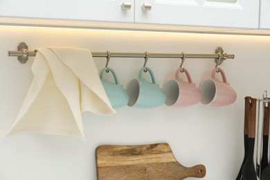 Photo of Clean waffle towel and cups hanging in kitchen, closeup