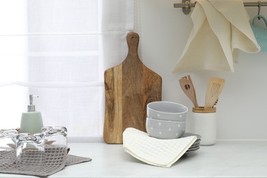 Photo of Clean dishware and waffle towels on countertop in kitchen