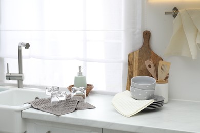 Photo of Clean dishware and waffle towels on countertop in kitchen