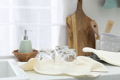 Photo of Clean dishware and waffle towels on countertop in kitchen