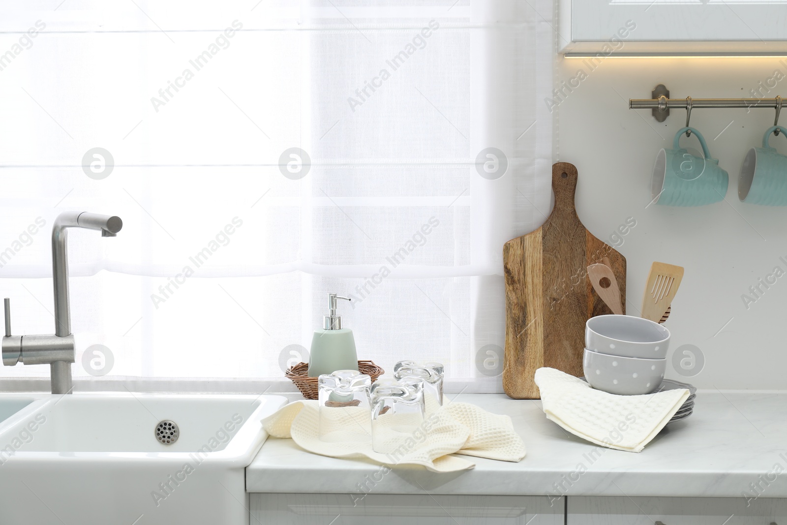 Photo of Clean dishware and waffle towels on countertop in kitchen