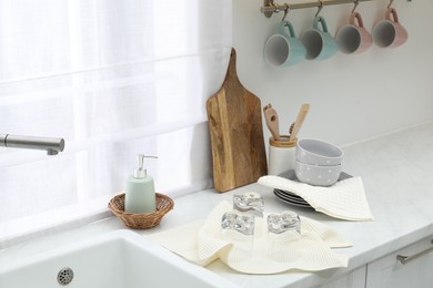 Photo of Clean dishware and waffle towels on countertop in kitchen
