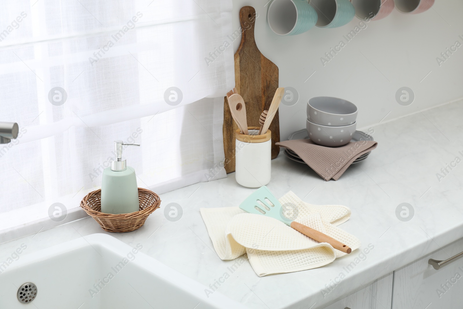Photo of Clean dishware and waffle towels on countertop in kitchen
