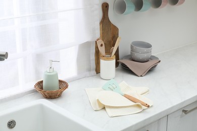 Photo of Clean dishware and waffle towels on countertop in kitchen
