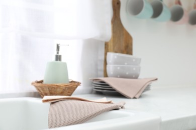 Photo of Clean dishware and waffle towels on countertop in kitchen, closeup