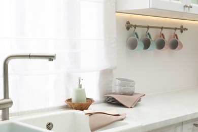 Photo of Clean dishware and waffle towels on countertop in kitchen