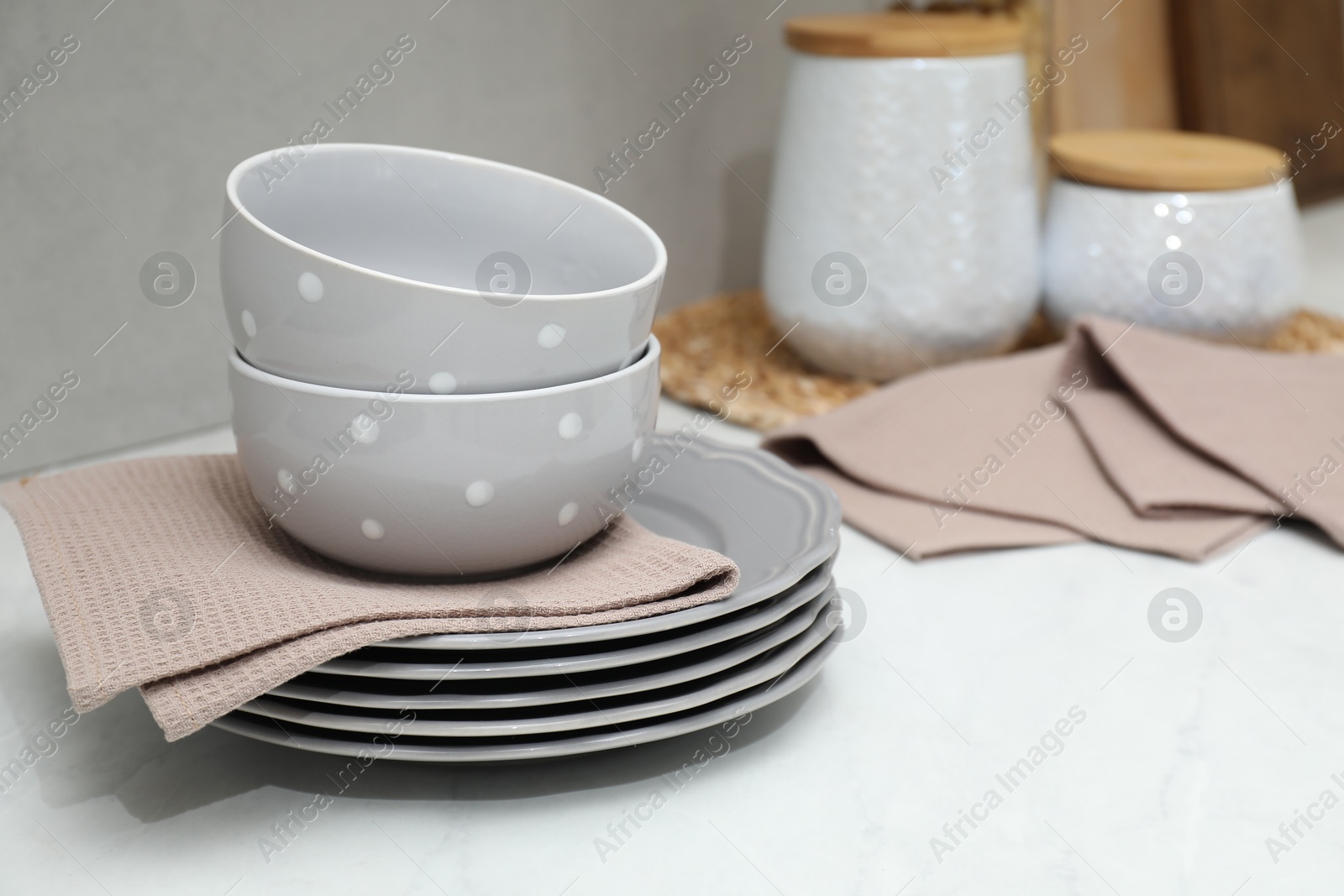 Photo of Clean dishware and waffle towels on countertop in kitchen, closeup