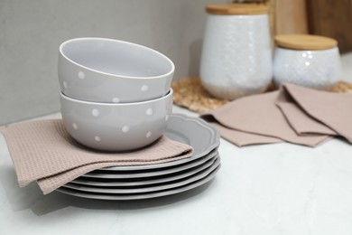 Photo of Clean dishware and waffle towels on countertop in kitchen, closeup