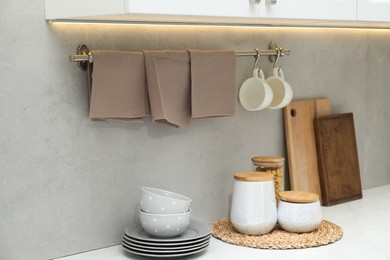 Photo of Clean dishware, waffle towels and raw pasta in kitchen