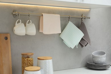 Photo of Clean dishware, waffle towels and raw pasta in kitchen