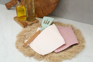 Photo of Clean waffle towels with turner and oil on countertop in kitchen