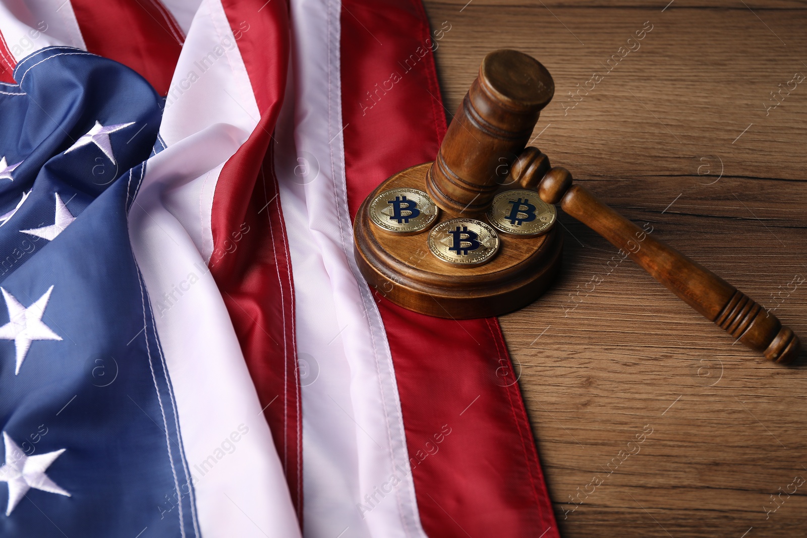 Cryptocurrency. Bitcoins, judge's gavel and American flag on wooden table, closeup Photo of Cryptocurrency. Bitcoins, judge's gavel and American flag on wooden table, closeup