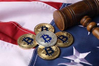 Photo of Cryptocurrency. Bitcoins and judge's gavel on American flag, closeup