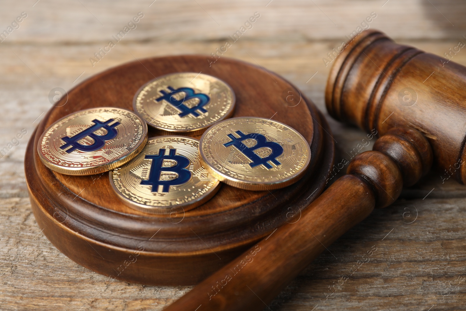Cryptocurrency. Bitcoins and judge's gavel on wooden table, closeup Photo of Cryptocurrency. Bitcoins and judge's gavel on wooden table, closeup