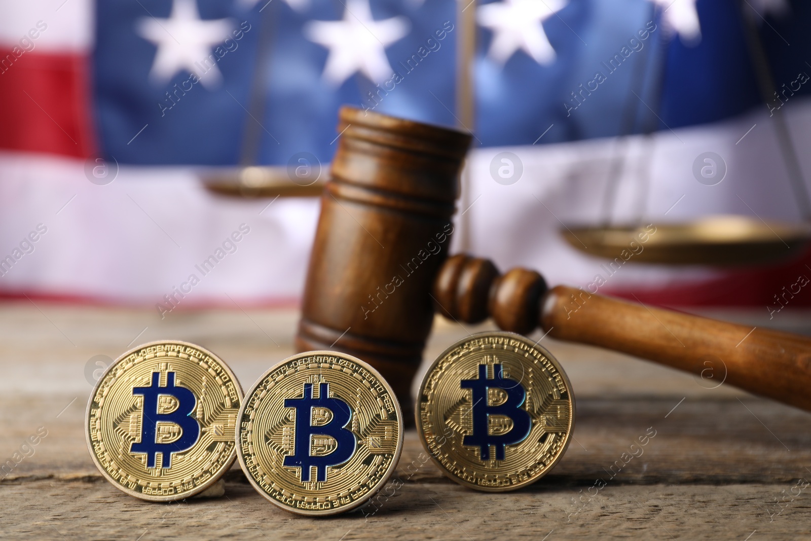 Cryptocurrency. Bitcoins, judge's gavel and scales on wooden table against American flag, closeup Photo of Cryptocurrency. Bitcoins, judge's gavel and scales on wooden table against American flag, closeup