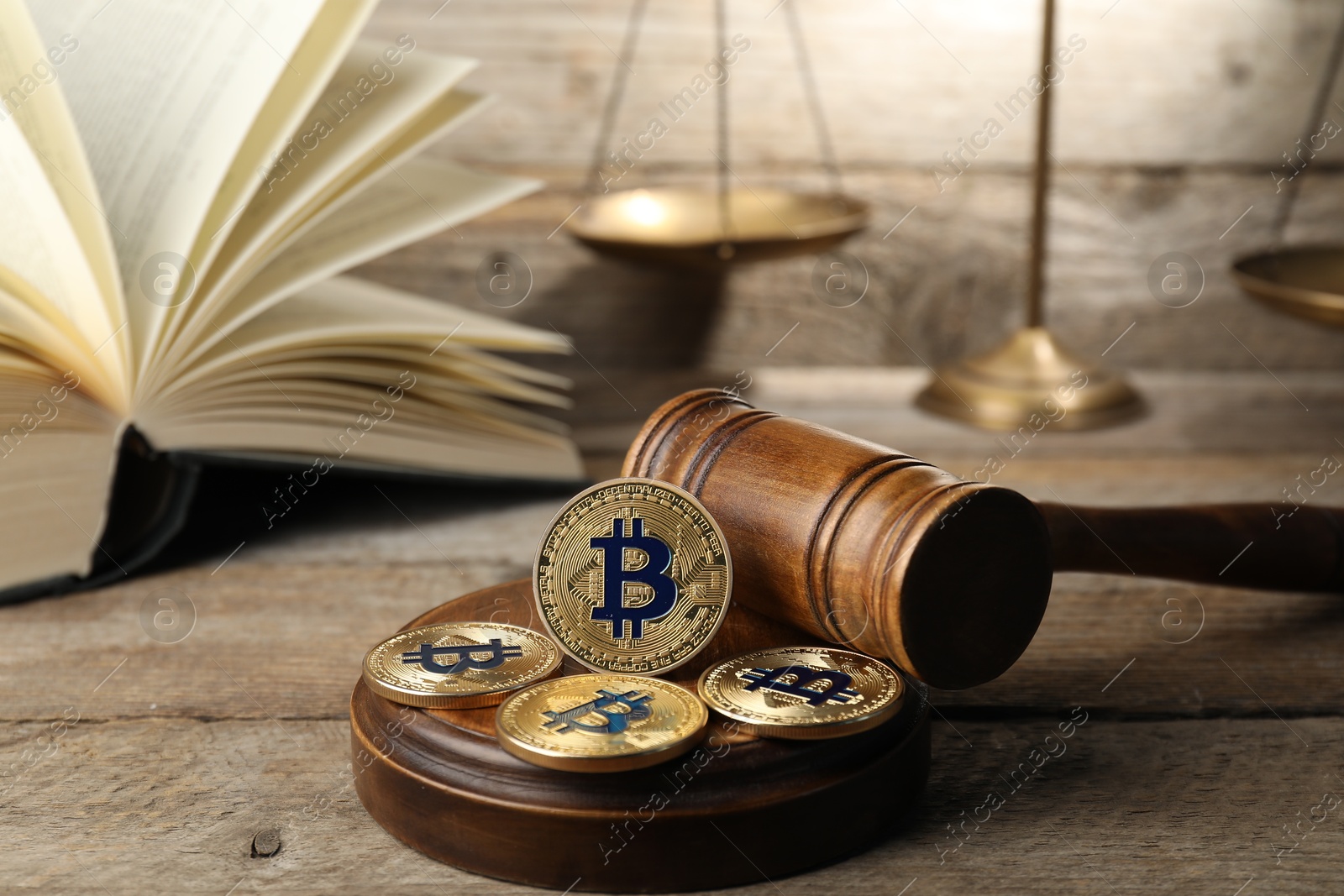 Cryptocurrency. Bitcoins, judge's gavel, book and scales on wooden table, closeup Photo of Cryptocurrency. Bitcoins, judge's gavel, book and scales on wooden table, closeup