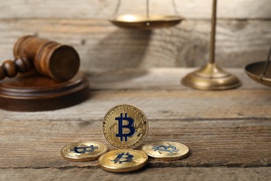 Photo of Cryptocurrency. Bitcoins, judge's gavel and scales on wooden table, closeup