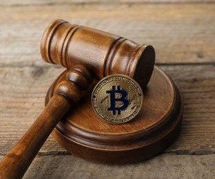 Photo of Cryptocurrency. Bitcoin and judge's gavel on wooden table, closeup