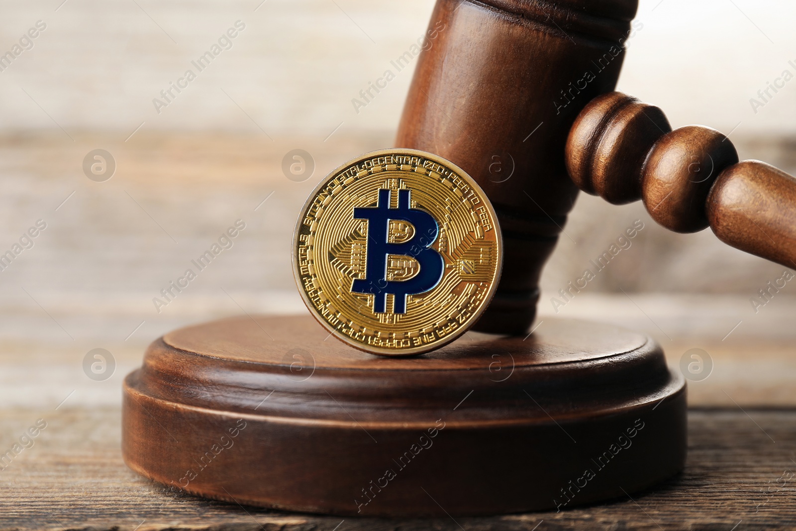 Cryptocurrency. Bitcoin and judge's gavel on wooden table, closeup Photo of Cryptocurrency. Bitcoin and judge's gavel on wooden table, closeup