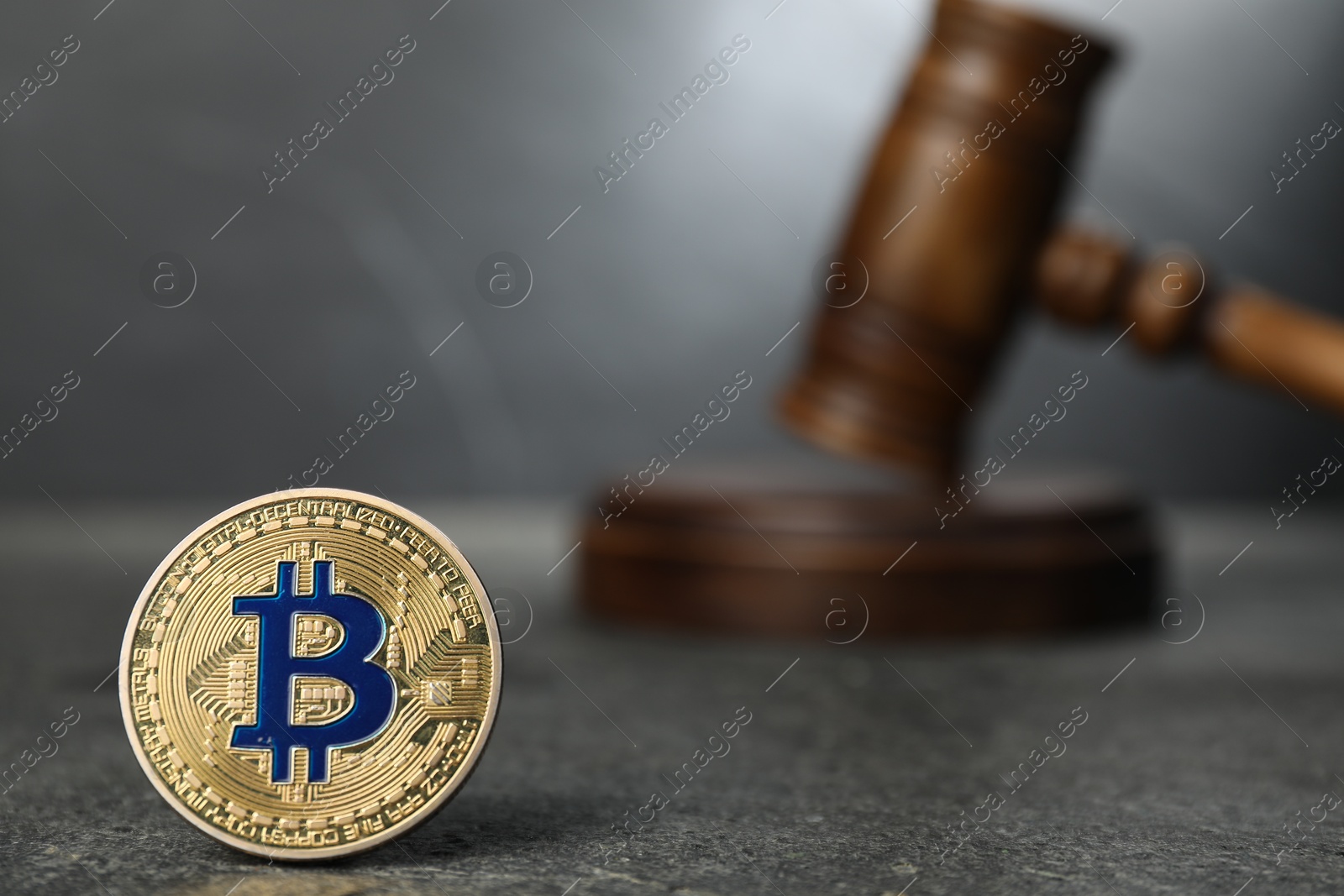 Photo of Cryptocurrency. Bitcoin and judge's gavel on grey table, closeup. Space for text