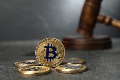 Photo of Cryptocurrency. Bitcoins and judge's gavel on grey table, closeup