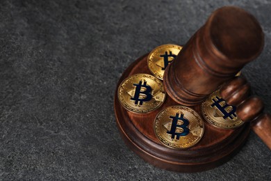 Photo of Cryptocurrency. Bitcoins and judge's gavel on grey table, closeup. Space for text