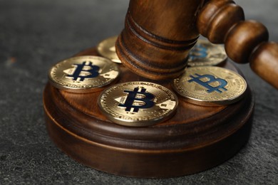 Photo of Cryptocurrency. Bitcoins and judge's gavel on grey table, closeup