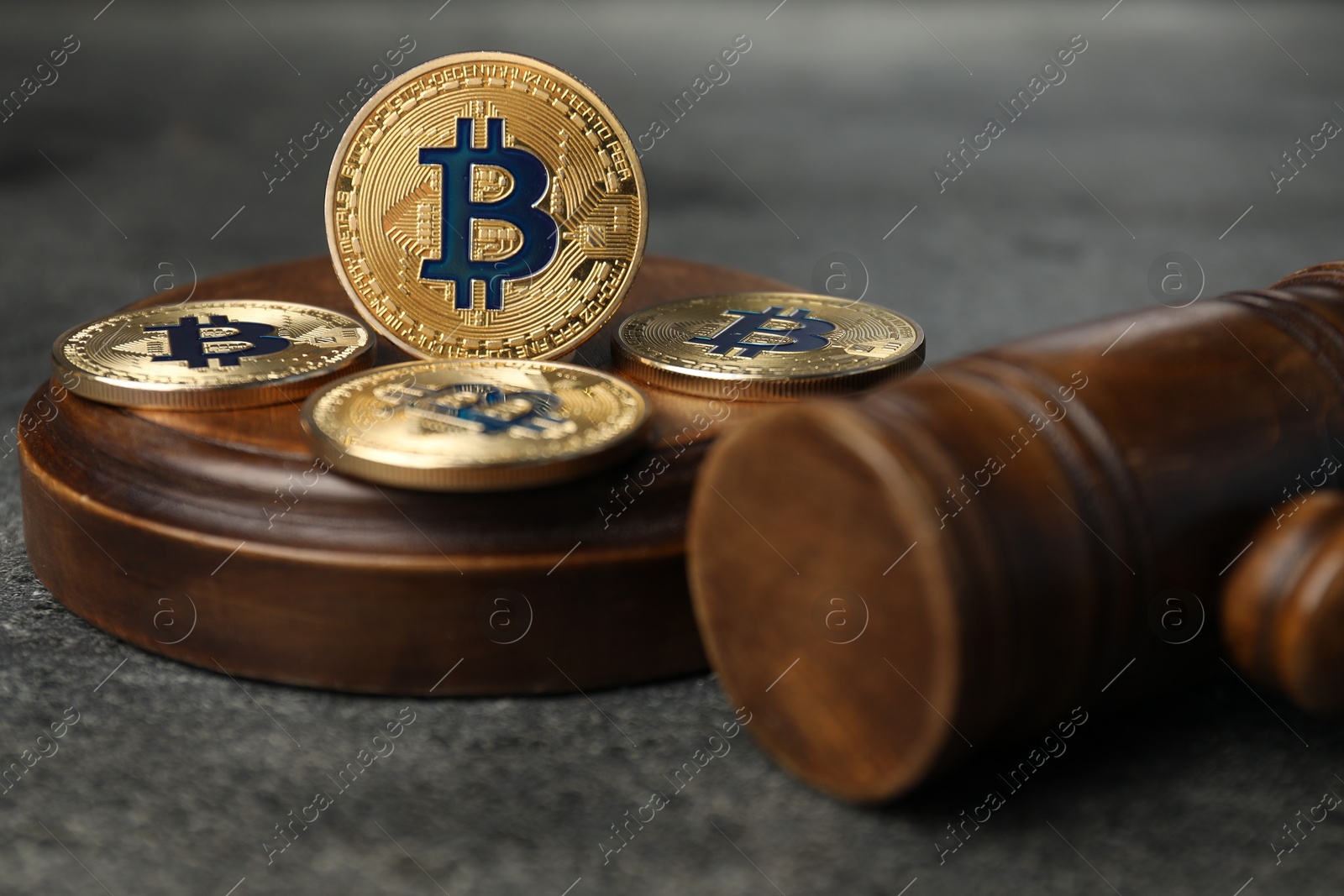 Cryptocurrency. Bitcoins and judge's gavel on grey table, closeup Photo of Cryptocurrency. Bitcoins and judge's gavel on grey table, closeup