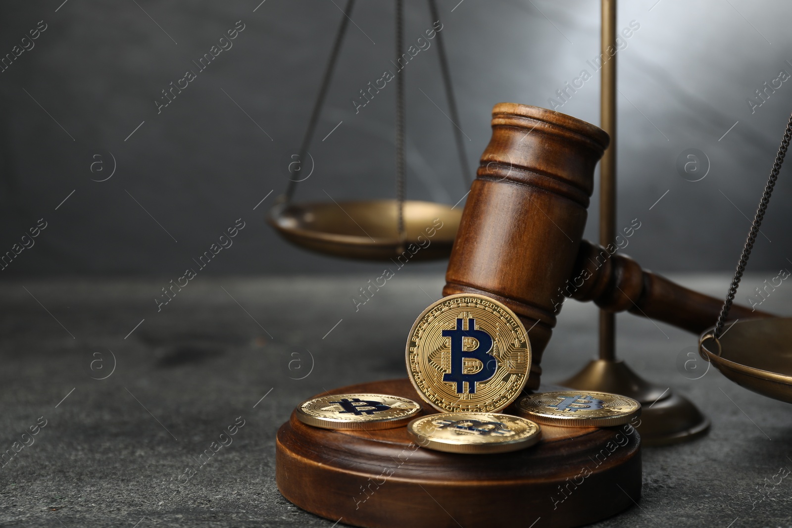Photo of Cryptocurrency. Bitcoins, judge's gavel and scales on grey table, closeup. Space for text