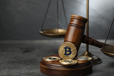 Photo of Cryptocurrency. Bitcoins, judge's gavel and scales on grey table, closeup. Space for text