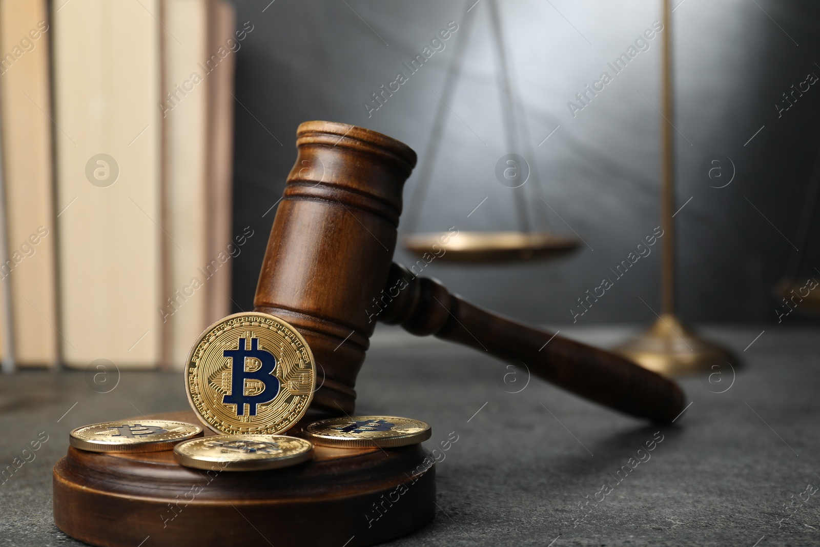 Photo of Cryptocurrency. Bitcoins, judge's gavel, books and scales on grey table, closeup